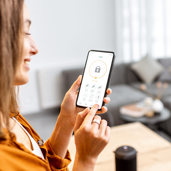 woman holding phone showing how to lock the house with an app